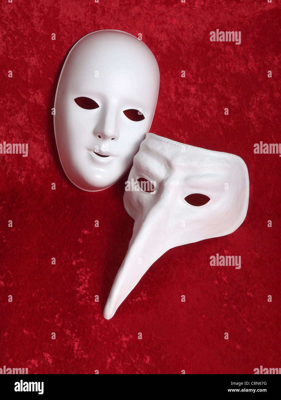 2 máscaras blancas sobre fondo de terciopelo rojo Fotografía de stock -  Alamy
