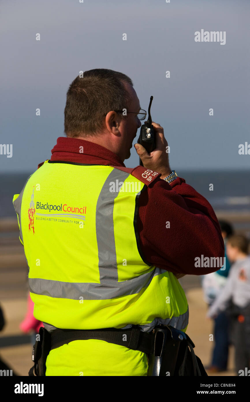 Empleado del consejo de Blackpool en chaleco de alta visibilidad y un walkie-talkie en Blackpool mar Foto de stock