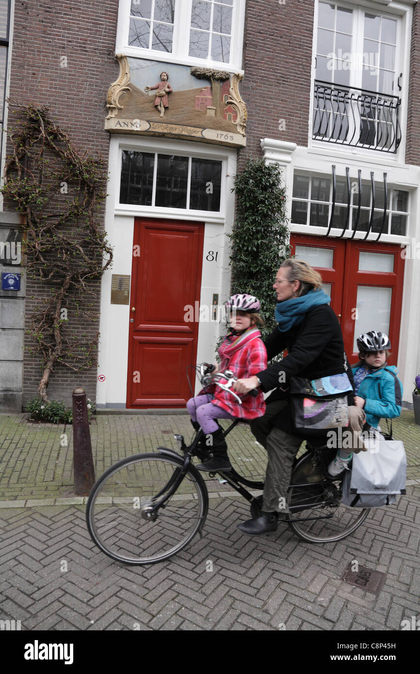 Mujer ciclista llevando dos niños pequeños, niño y niña en una bicicleta  holandesa negro Joordan Amsterdam Holanda Holanda Fotografía de stock -  Alamy