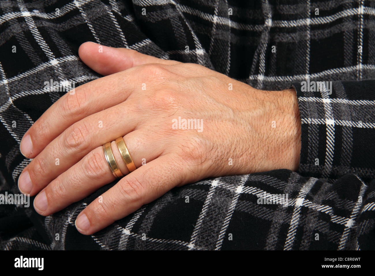 La bigamia símbolo - hombre mano con dos anillos de desyerba Fotografía de  stock - Alamy