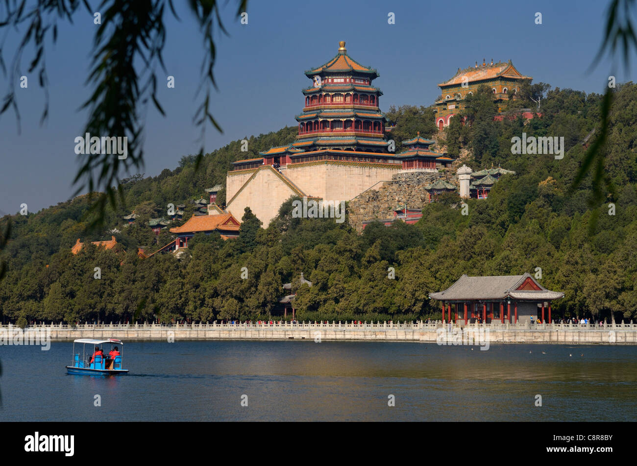 Embarcaciones de remo en el lago Kunming con fragancia budista y el mar de sabiduría templos en el palacio de verano de Pekín, China Foto de stock