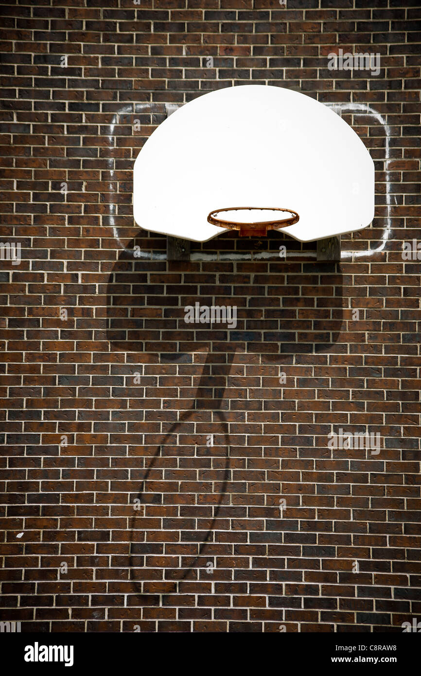 Un aro de baloncesto netless tablero blanco y marrón, fijada a una pared de ladrillo. Foto de stock