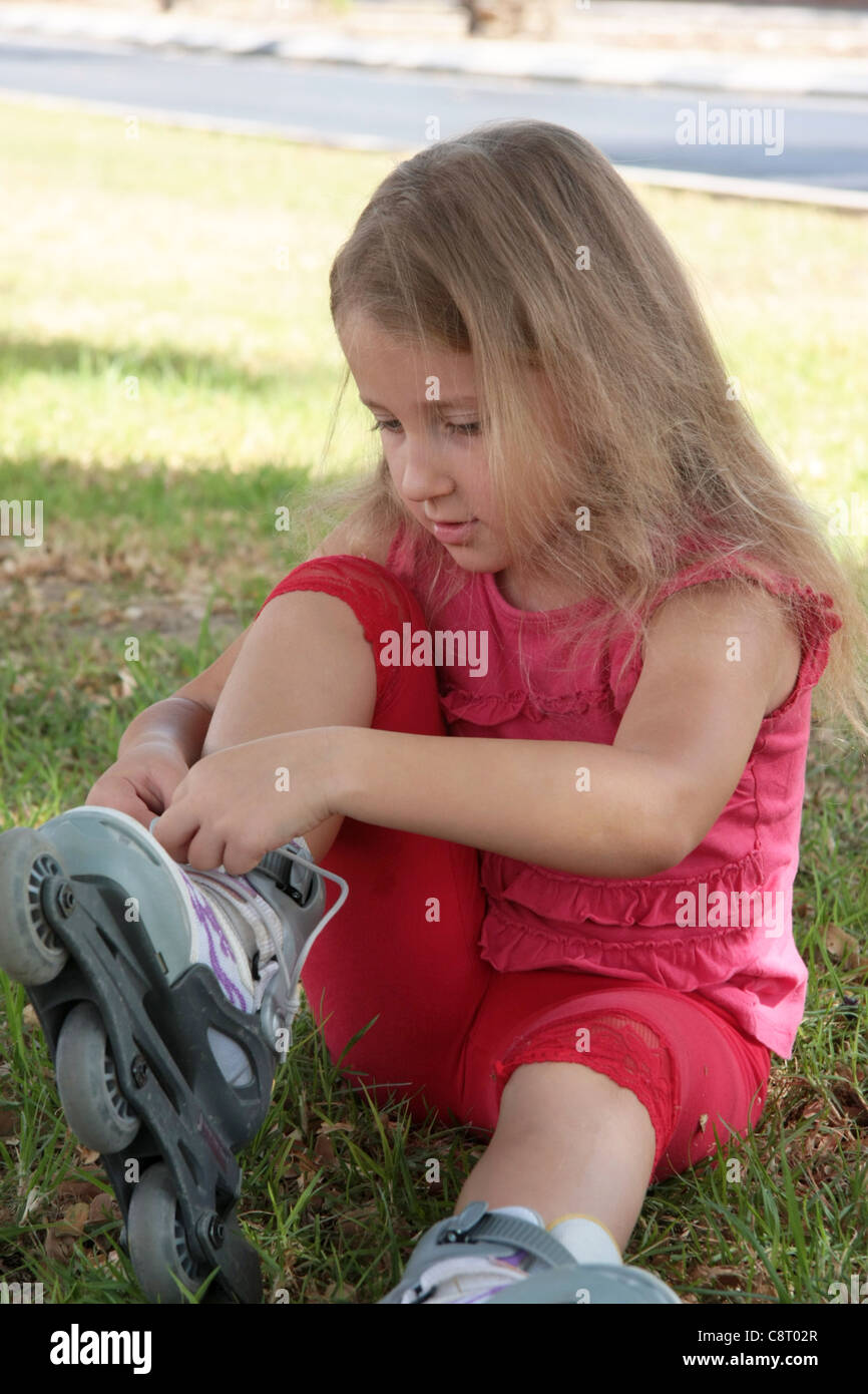 Retrato de una niña vestir rodillos en vestido rojo Foto de stock