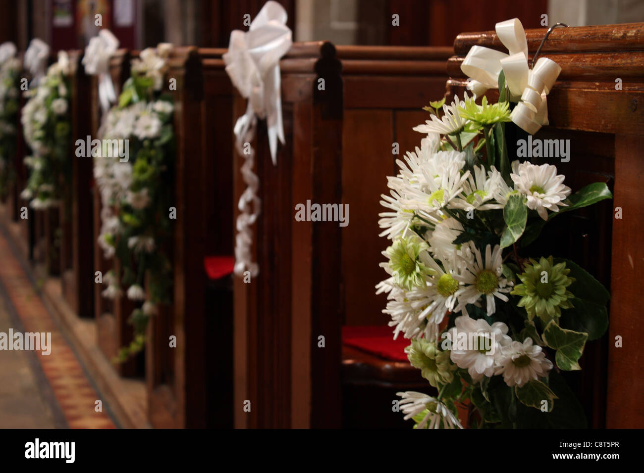 Iglesia bancas con arreglos florales de boda de flores en blanco y verde al  final de cada una de las bancas Fotografía de stock - Alamy
