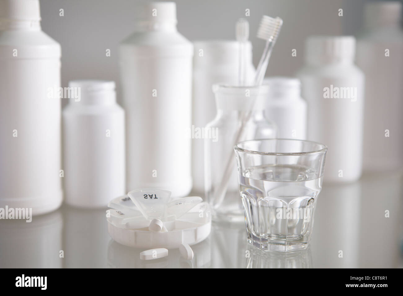 Vaso de agua con el cepillo de dientes en un tarro de vidrio con botellas  en el fondo Fotografía de stock - Alamy