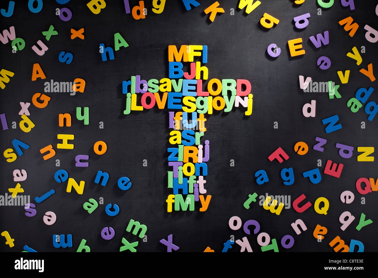 Alfabetos multicolores dispuestos en forma de cruz Foto de stock