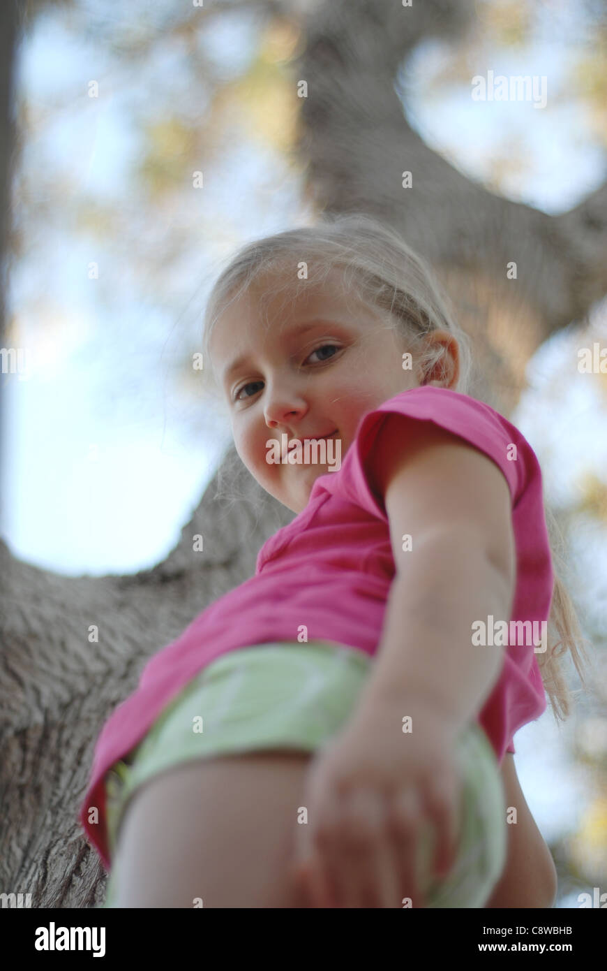 Los niños chica plantea árbol de fondo Foto de stock