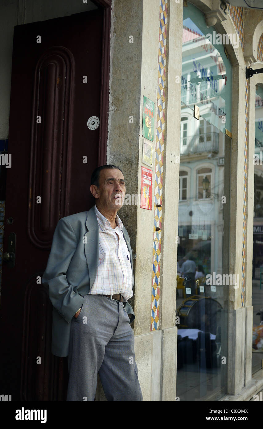Una cándida imagen de un hombre portugués de pie en la puerta de un pequeño  hotel y viendo una banda estudiantil en Coimbra, Portugal Fotografía de  stock - Alamy
