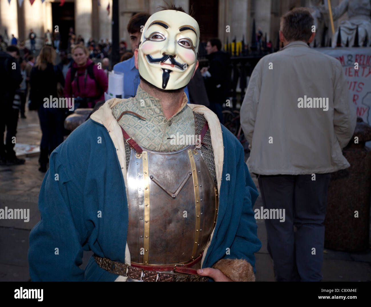 Un manifestante vistiendo un traje de armadura y una máscara de V, Guy Fawks, la Catedral de San Pablo, Londres, Inglaterra, Reino Unido. Foto de stock