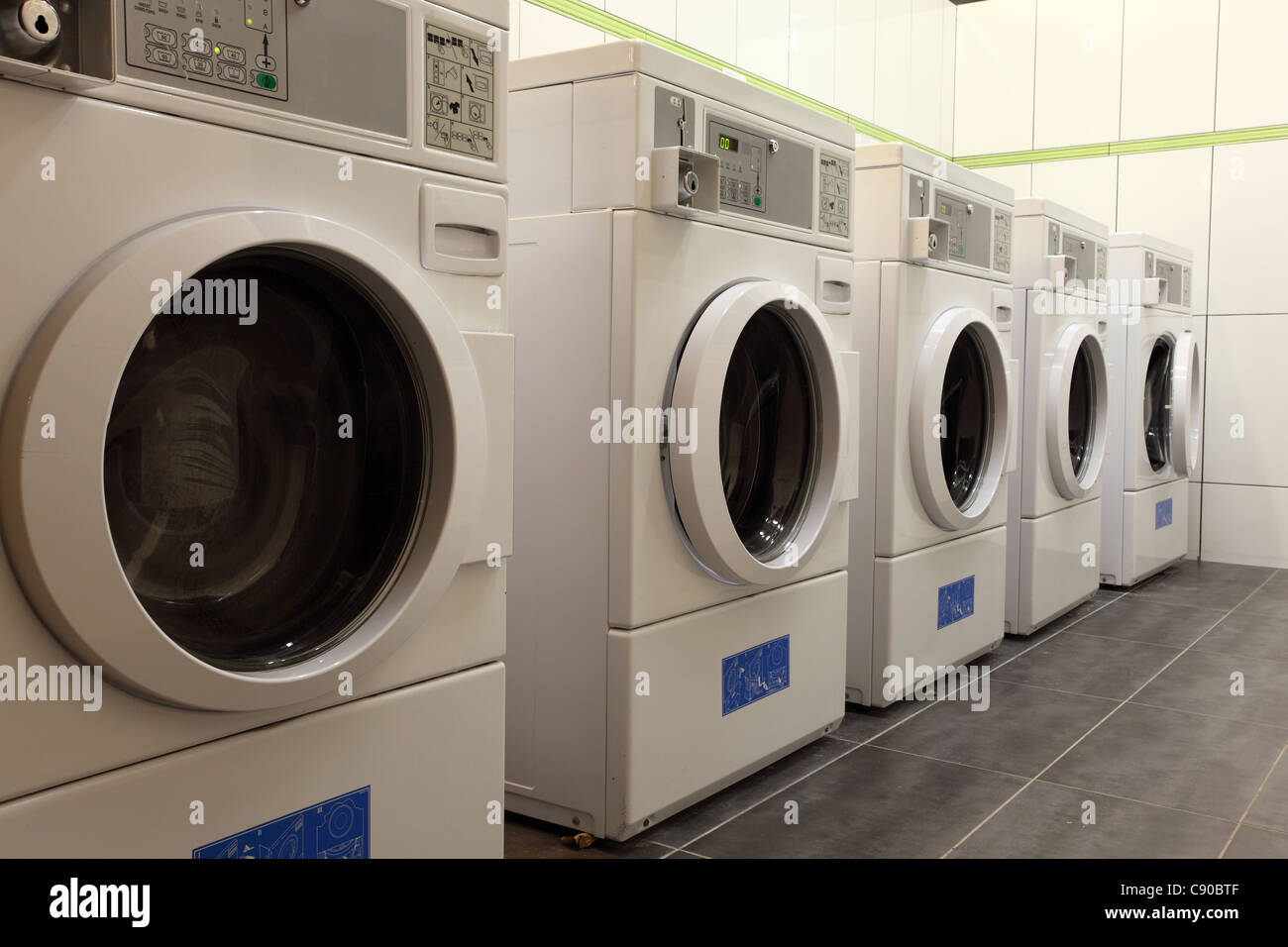 Máquinas de lavar ropa en una lavandería de monedas Fotografía de stock -  Alamy