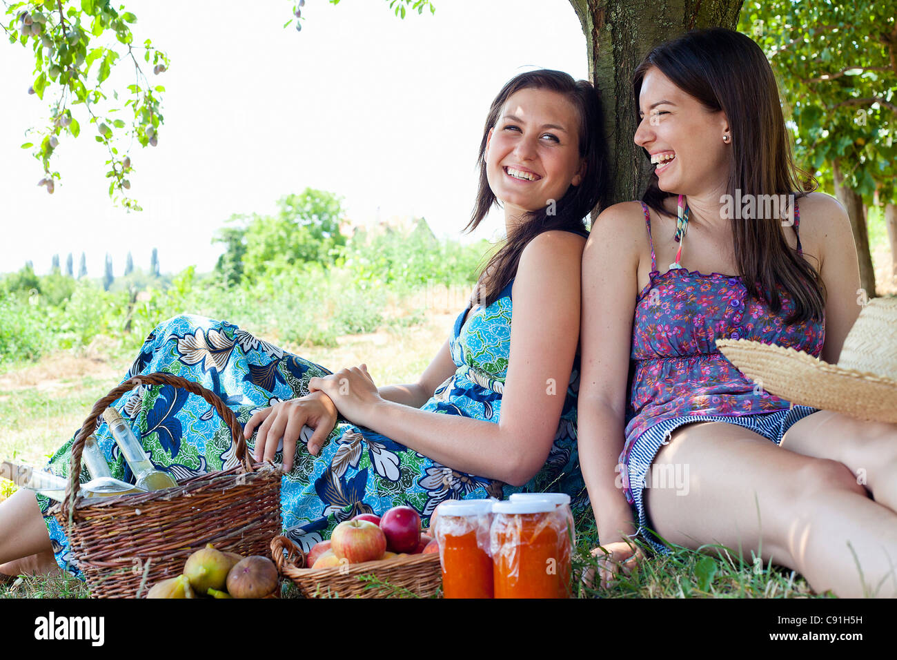 Mujer sonriente picnics en huerto Foto de stock