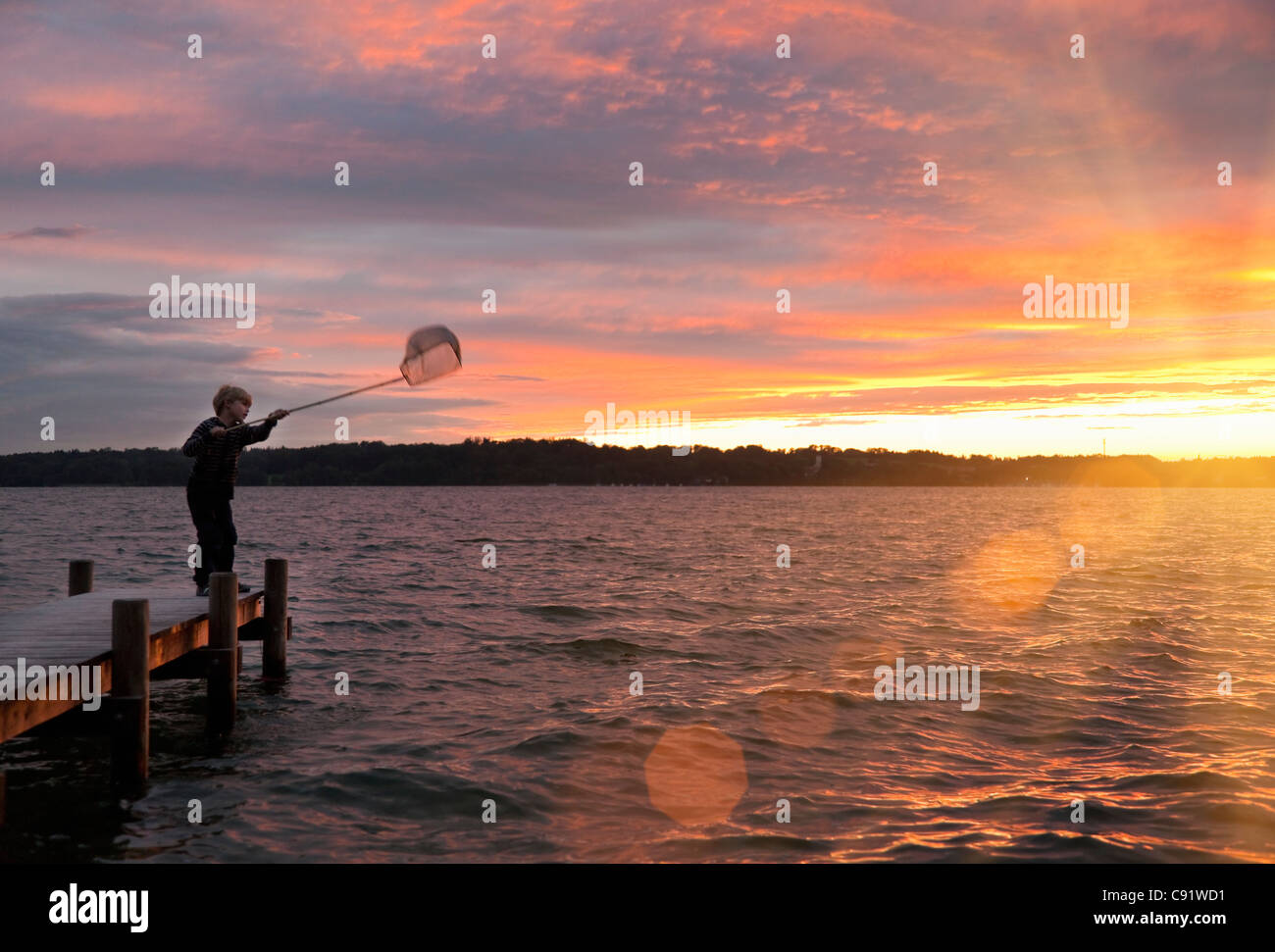 Chico pesca con red en el lago Foto de stock