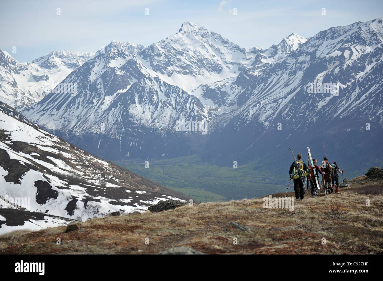 Grupo de esquiadores de travesía de pie en una cresta de Raina Pico con vistas a las montañas Chugach, Alaska Foto de stock