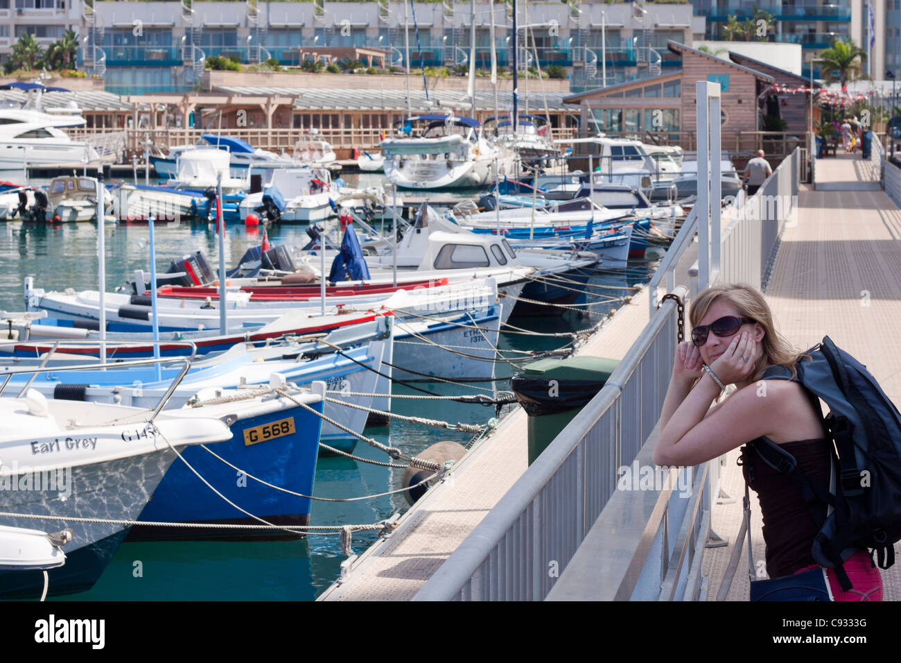 Retrato de mujer joven y barcos en Ocean Village, Gibraltar. Foto de stock