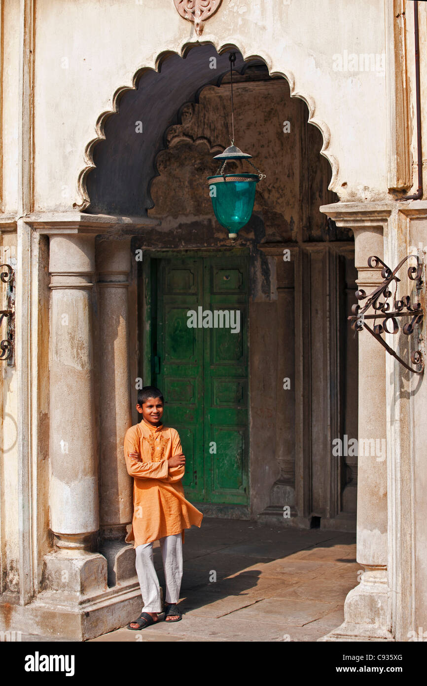 Un estudiante se relaja en un arco de la Imambara Hugli impresionante edificio. Foto de stock