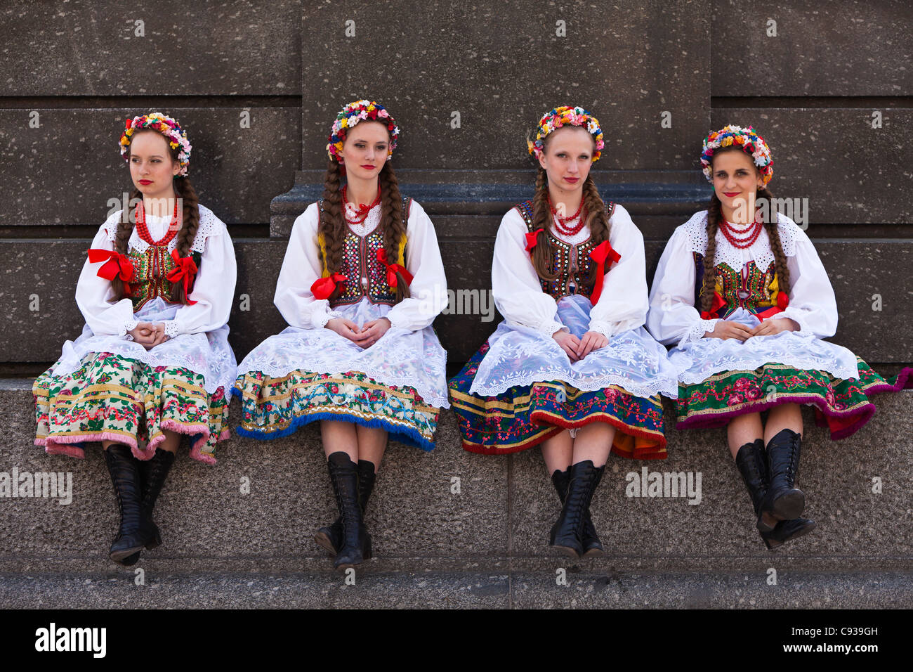 Modernizar tinción compensación Polonia, Cracovia. Las niñas polaco en traje tradicional sentados en la  base de la estatua Fotografía de stock - Alamy