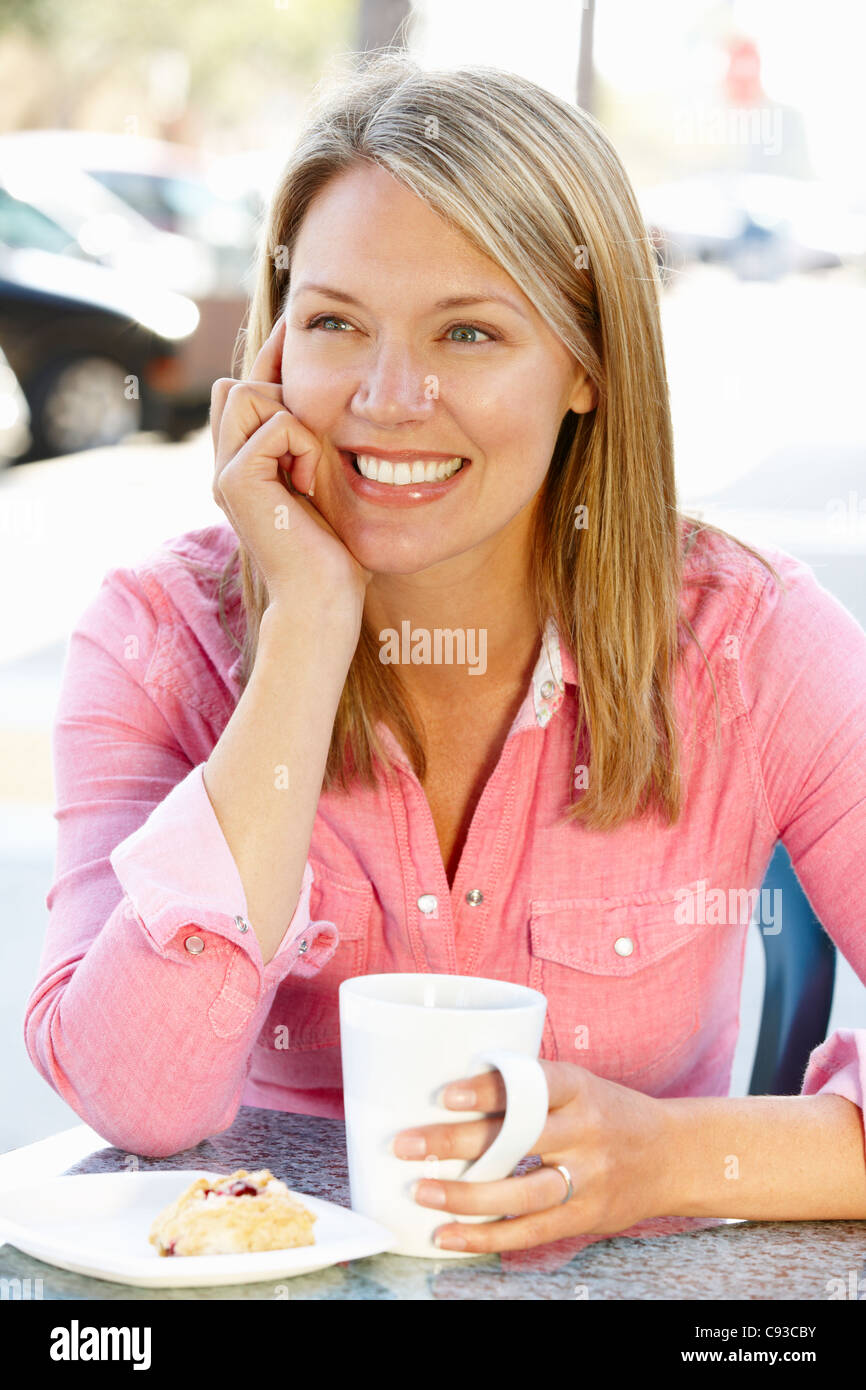 Mujer sentada en la acera cafÃ© Foto de stock