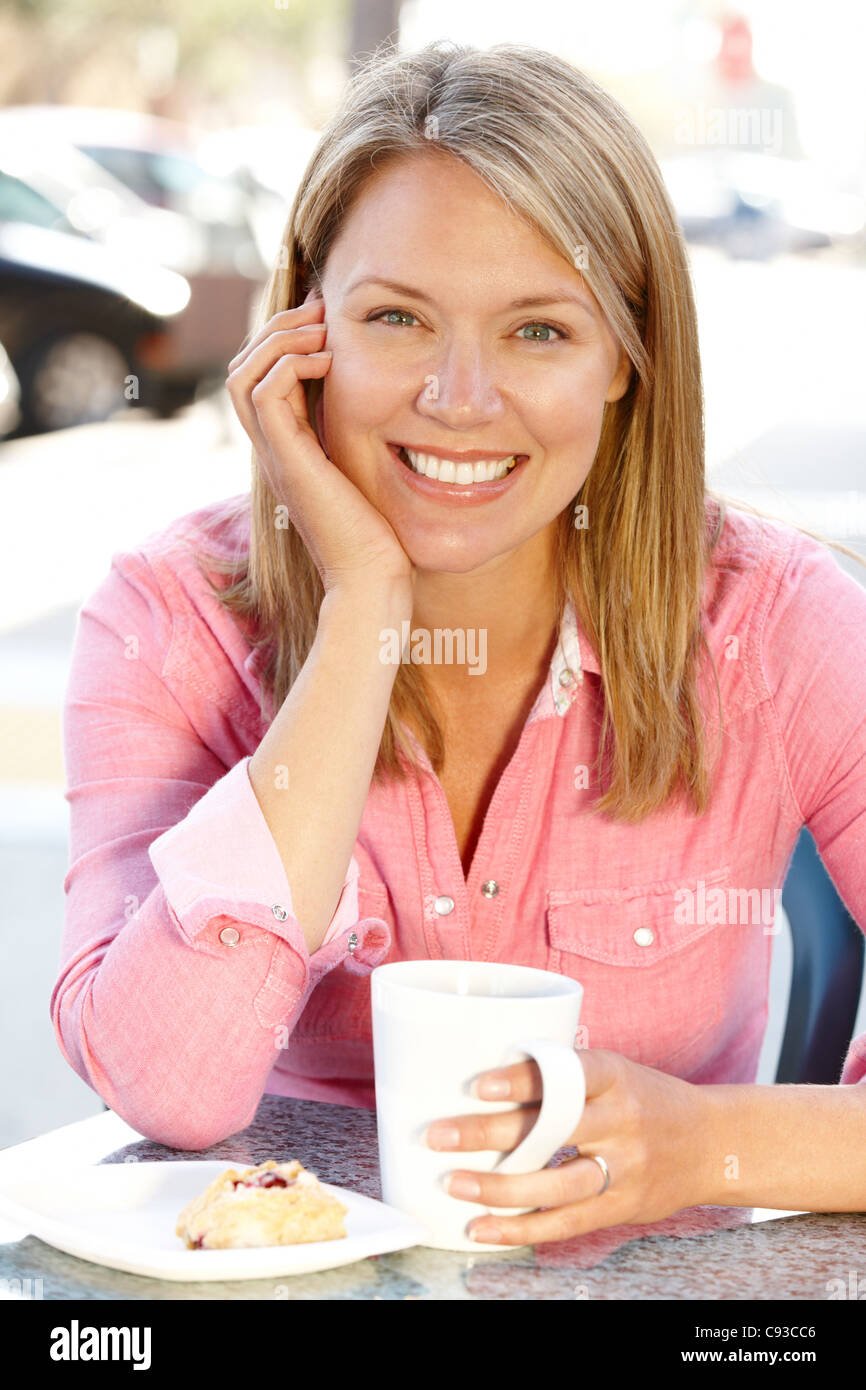 Mujer sentada en la acera cafÃ© Foto de stock