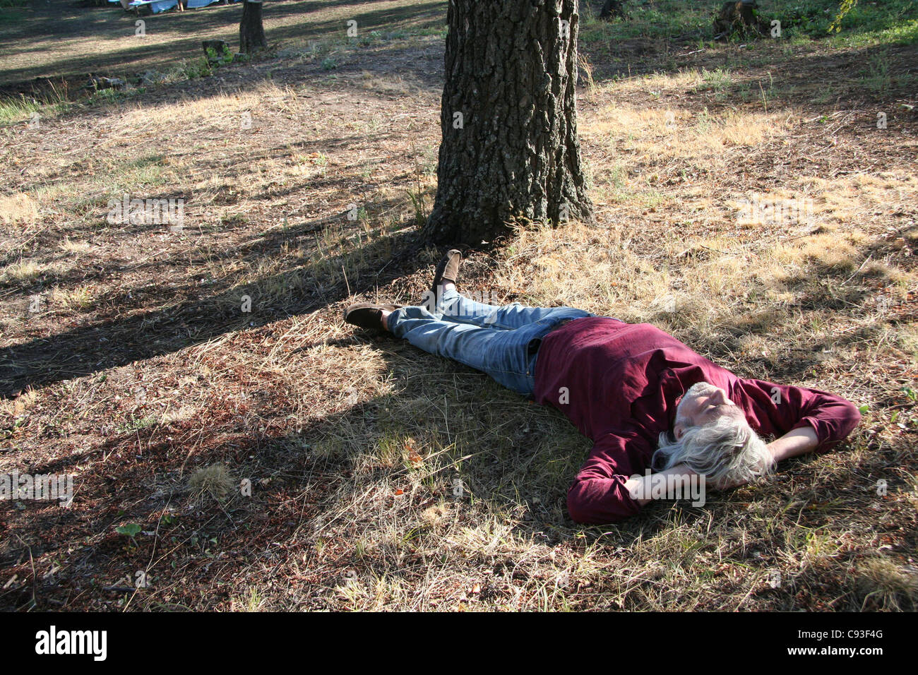 El hombre llevaba una camiseta roja, dormir una siesta en el suelo Foto de stock