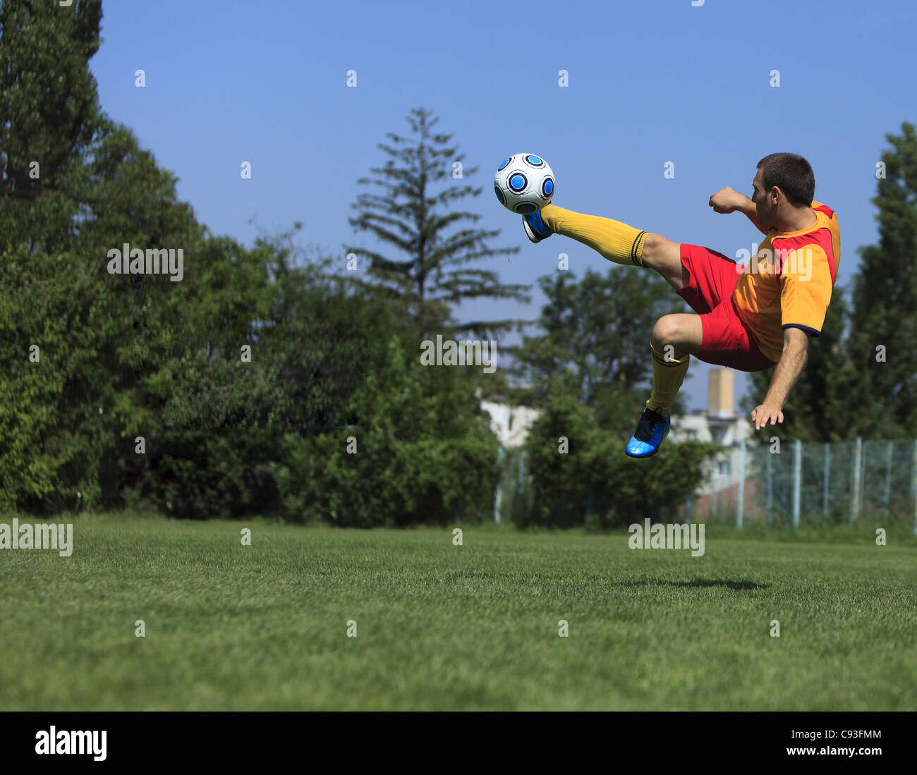 Un jugador de fútbol patear el balón en una posición acrobática. Foto de stock