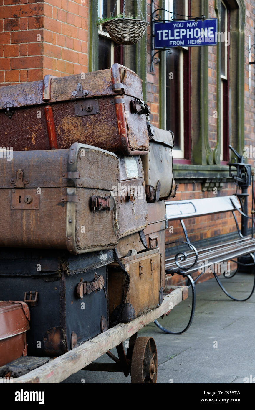 Viejas maletas apiladas en un carrito en una estación de tren recreando una  escena de viajes comúnmente visto en los años 40, 50 y 60 Fotografía de  stock - Alamy