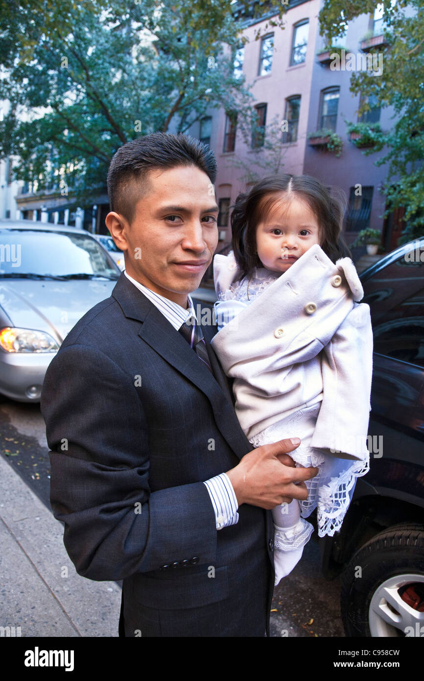 Orgulloso padre hispano celebración bright eyed hija vistiendo ropa de  bautizo en el lado oeste de Manhattan en Nueva York la acera Fotografía de  stock - Alamy
