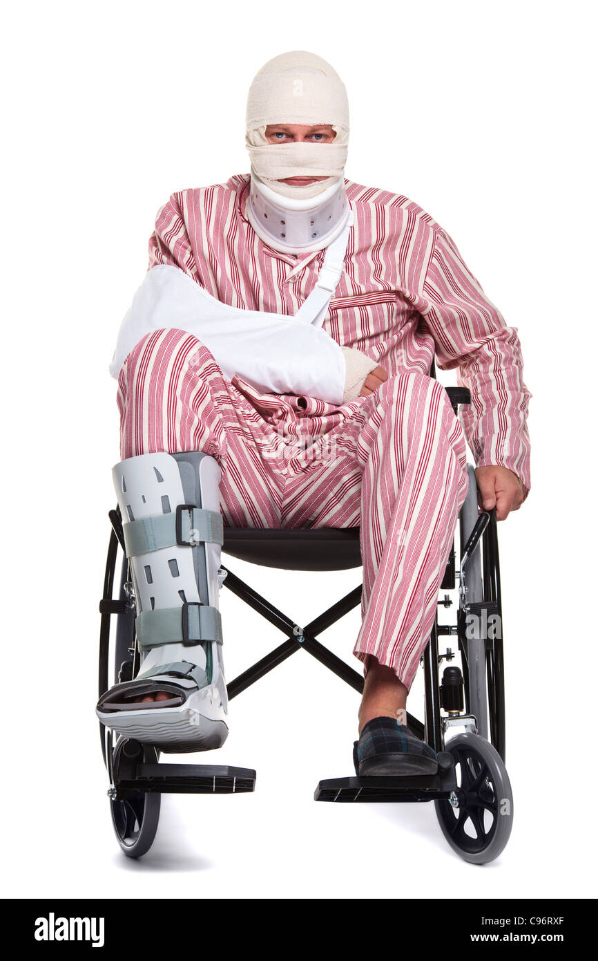 Foto de un hombre con varias heridas vistiendo pyjames seccionado y sentado en una silla de ruedas. Foto de stock