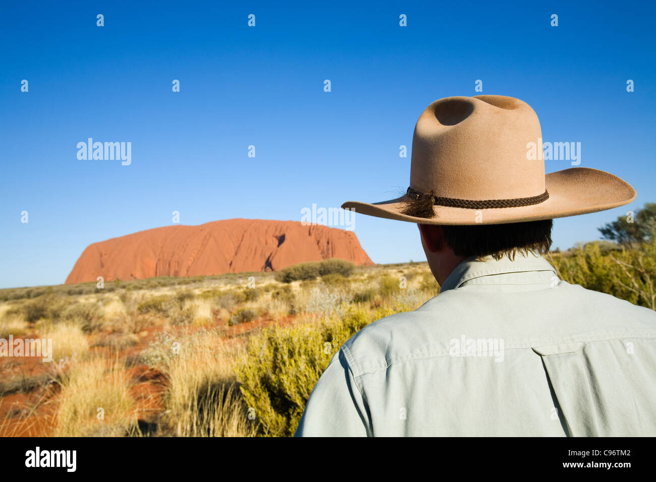 Un outback guía mirando hacia Uluru (Ayers Rock). El Parque Nacional de Uluru-Kata Tjuta, el Territorio del Norte, Australia Foto de stock