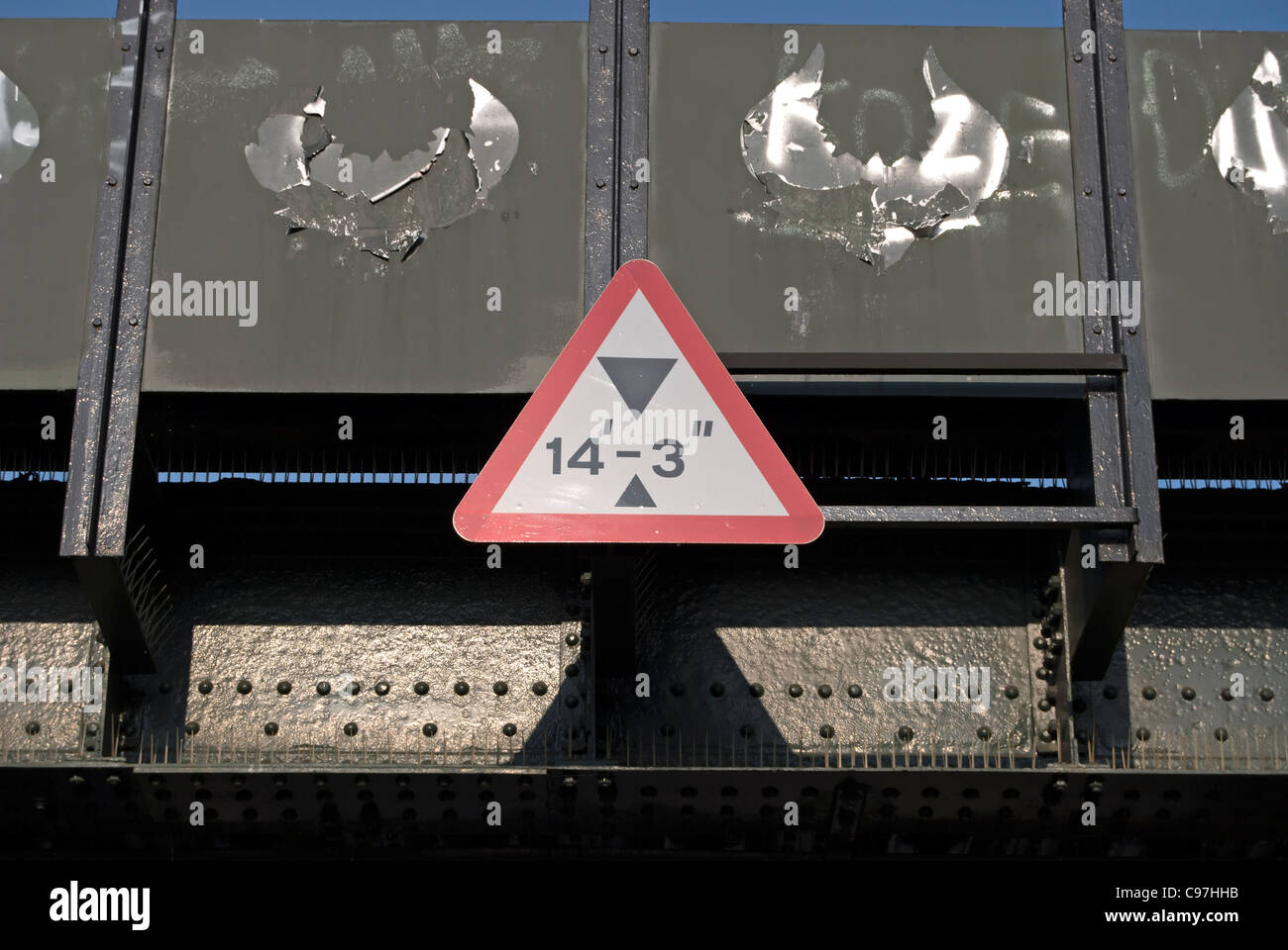 Señal de carretera británico Aviso de limitación de altura, en un puente ferroviario en Hampton Wick, Middlesex, Inglaterra Foto de stock