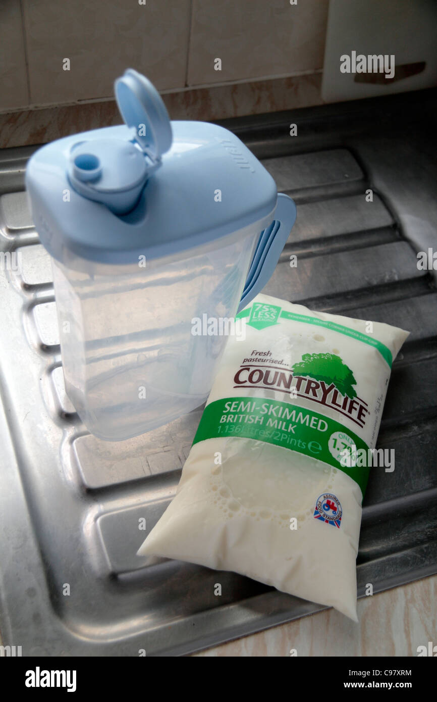 Una bolsa de leche y Jugit sentado en un fregadero de la cocina. Las bolsas de leche están diseñados para ser la forma más ecológica para consumir la leche en el Reino Unido. Foto de stock
