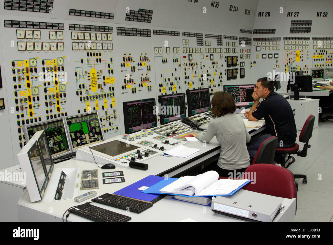 Sala de Control de la central nuclear de Kozloduy, Bulgaria, el personal detrás de pantallas, pared de diales de control Foto de stock