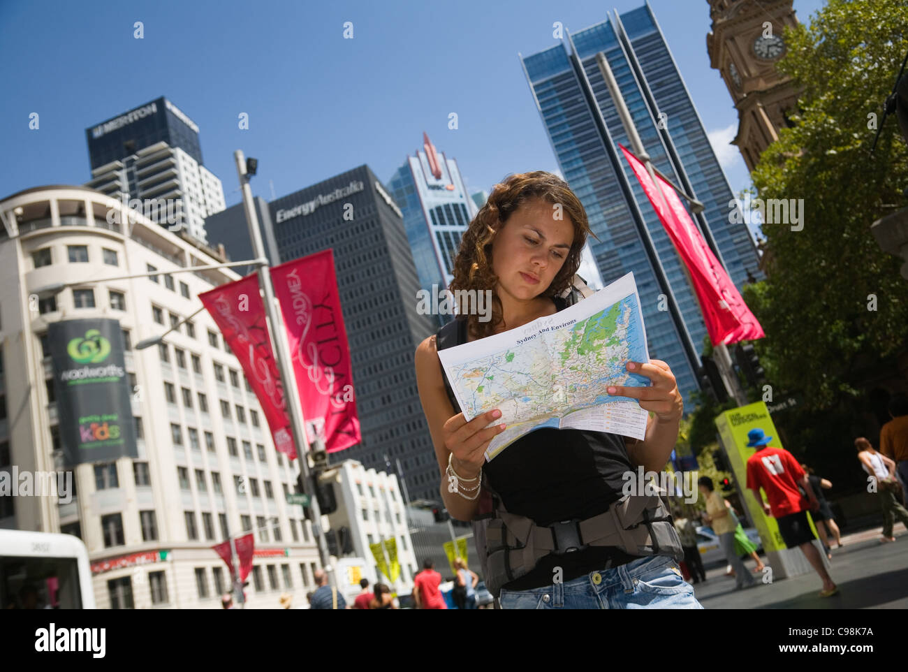 Mochilero femenino leer mapa con vistas al horizonte de la ciudad de fondo. Sydney, New South Wales, Australia Foto de stock
