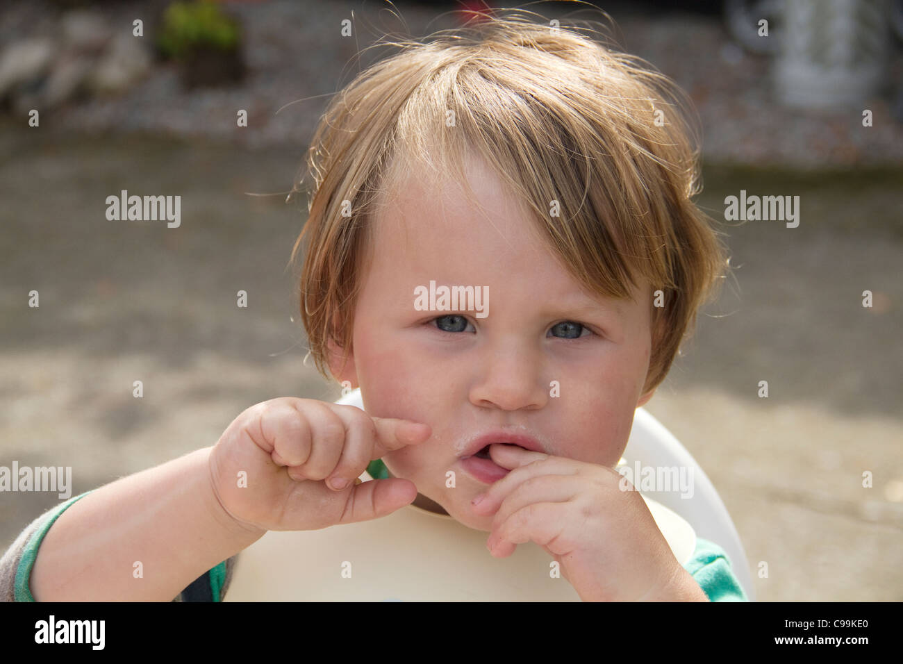 Niño mirando desconcertados después de comer Foto de stock