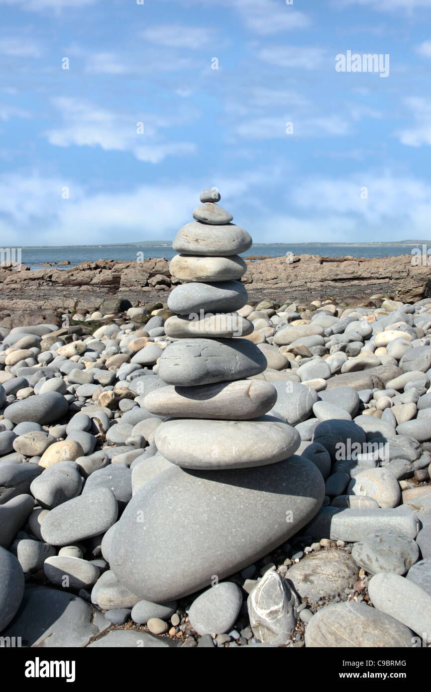 Rocas equilibrada en una tranquila playa espiritual en la costa de Irlanda Foto de stock