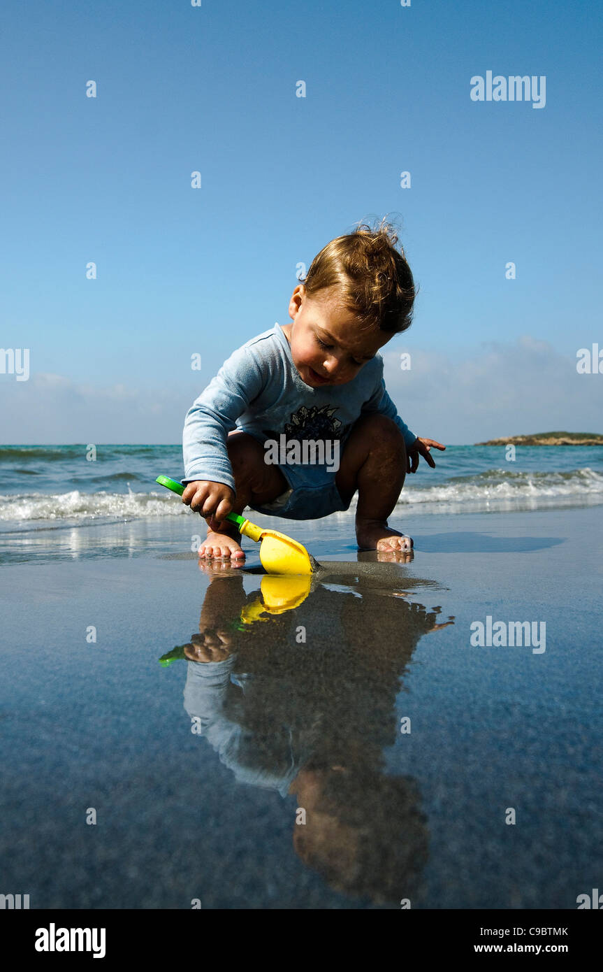 Dos años de Baby Boy juega en la playa Foto de stock