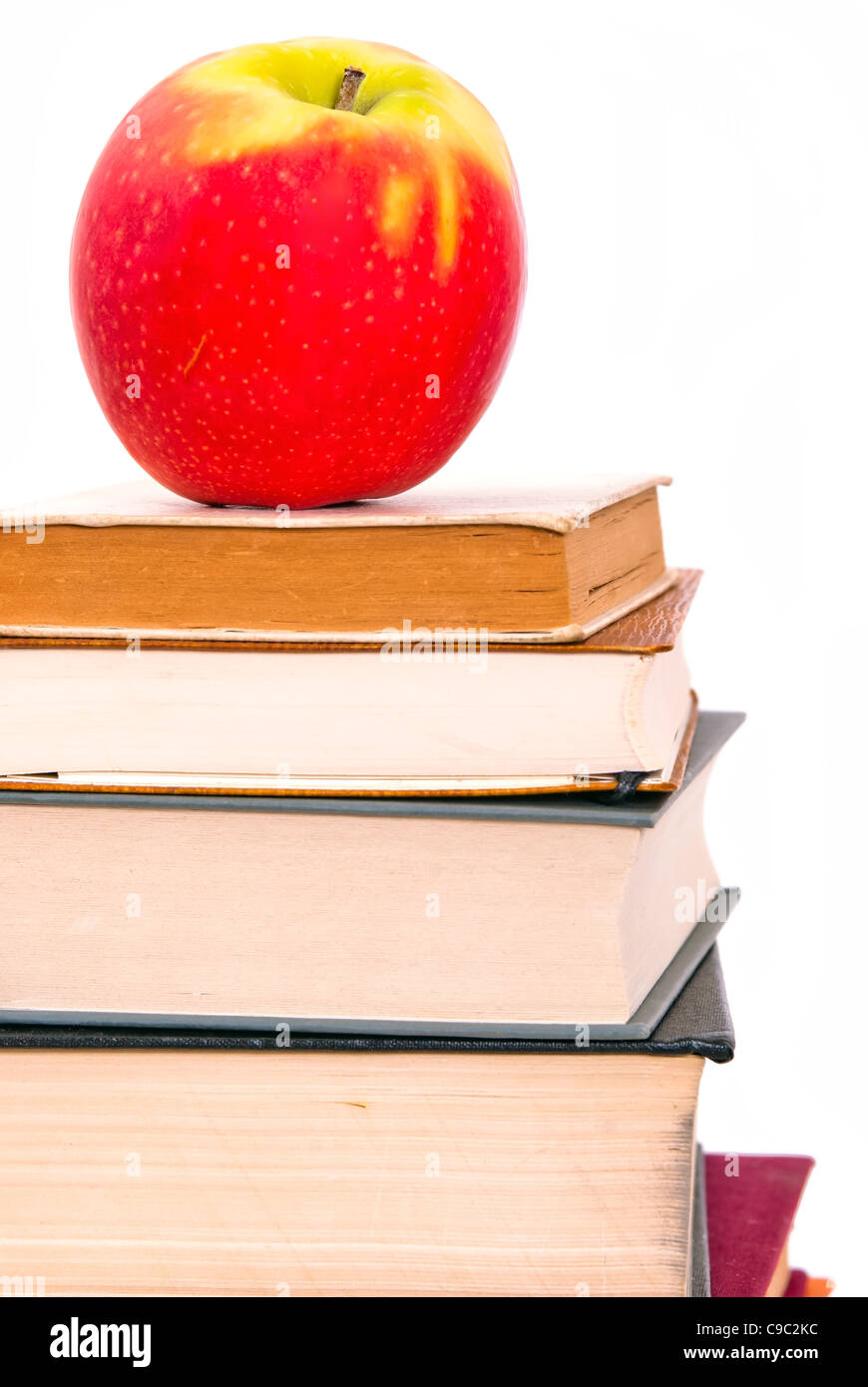 Un jugoso apple yace sobre un montón de libros Foto de stock