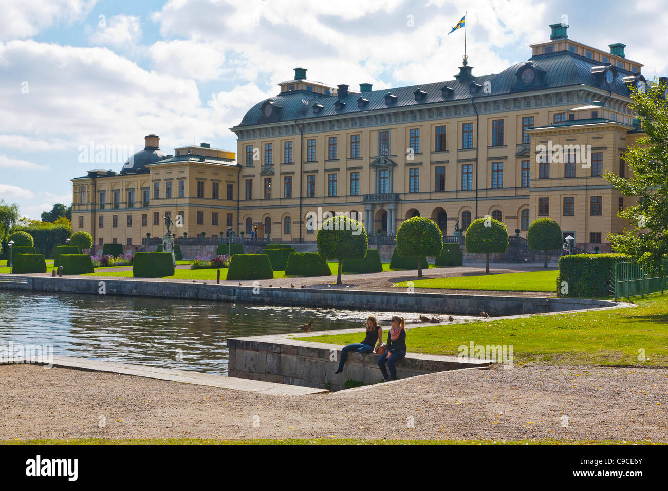 Dos mujeres sentadas por el agua en el Palacio Real de Drottningholm, Estocolmo, Suecia. Foto de stock