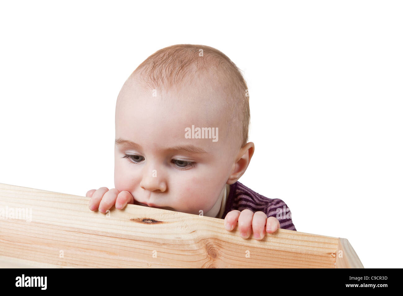 Bebé mirando en caja de madera. aislado sobre fondo blanco. Foto de stock