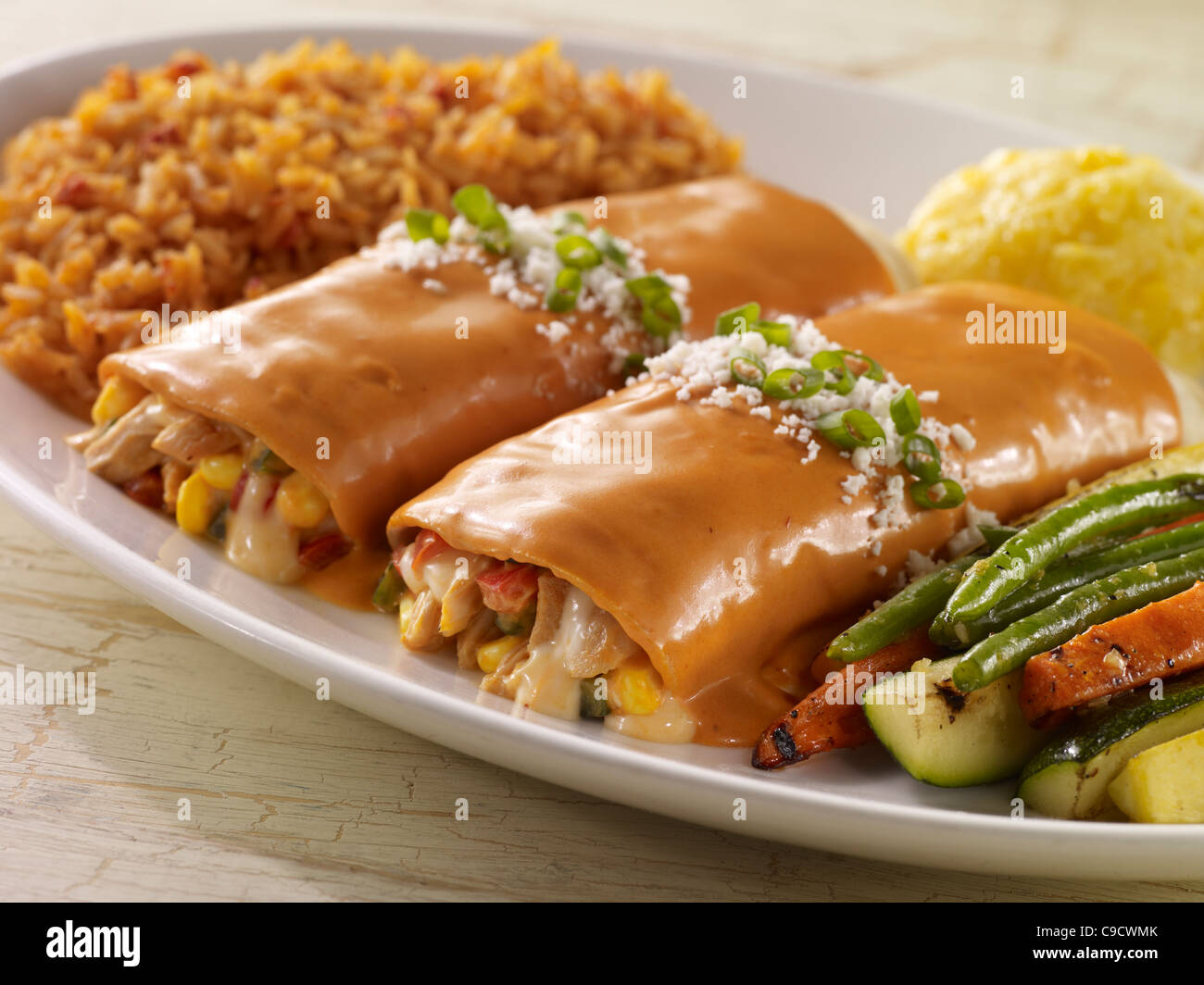 Dos chipotle enchiladas de pollo y verduras, coronado con salsa roja y