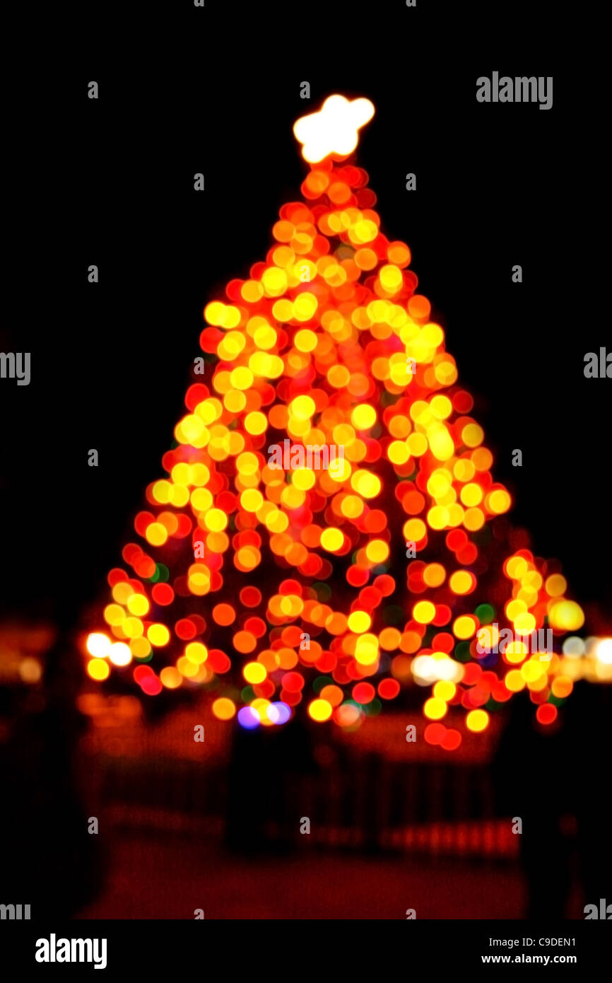 Árbol de Navidad exterior borrosa en la noche con fondo negro Foto de stock