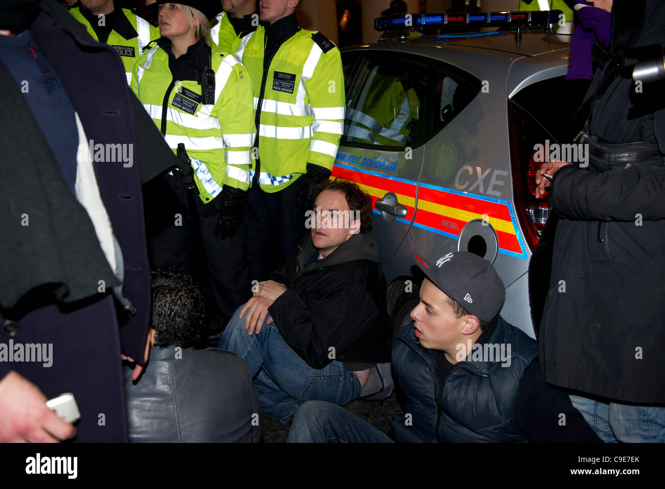 30 Nov 2011, Haymarket, Londres. Los manifestantes intentan bloquear la carretera para impedir que un vehículo de la policía dejando conteniendo prisioneros que fueron arrestados durante la breve ocupación de Panton House de Londres. El sentarse protesta fue breve y la policía pasó rápidamente a los manifestantes. Foto de stock