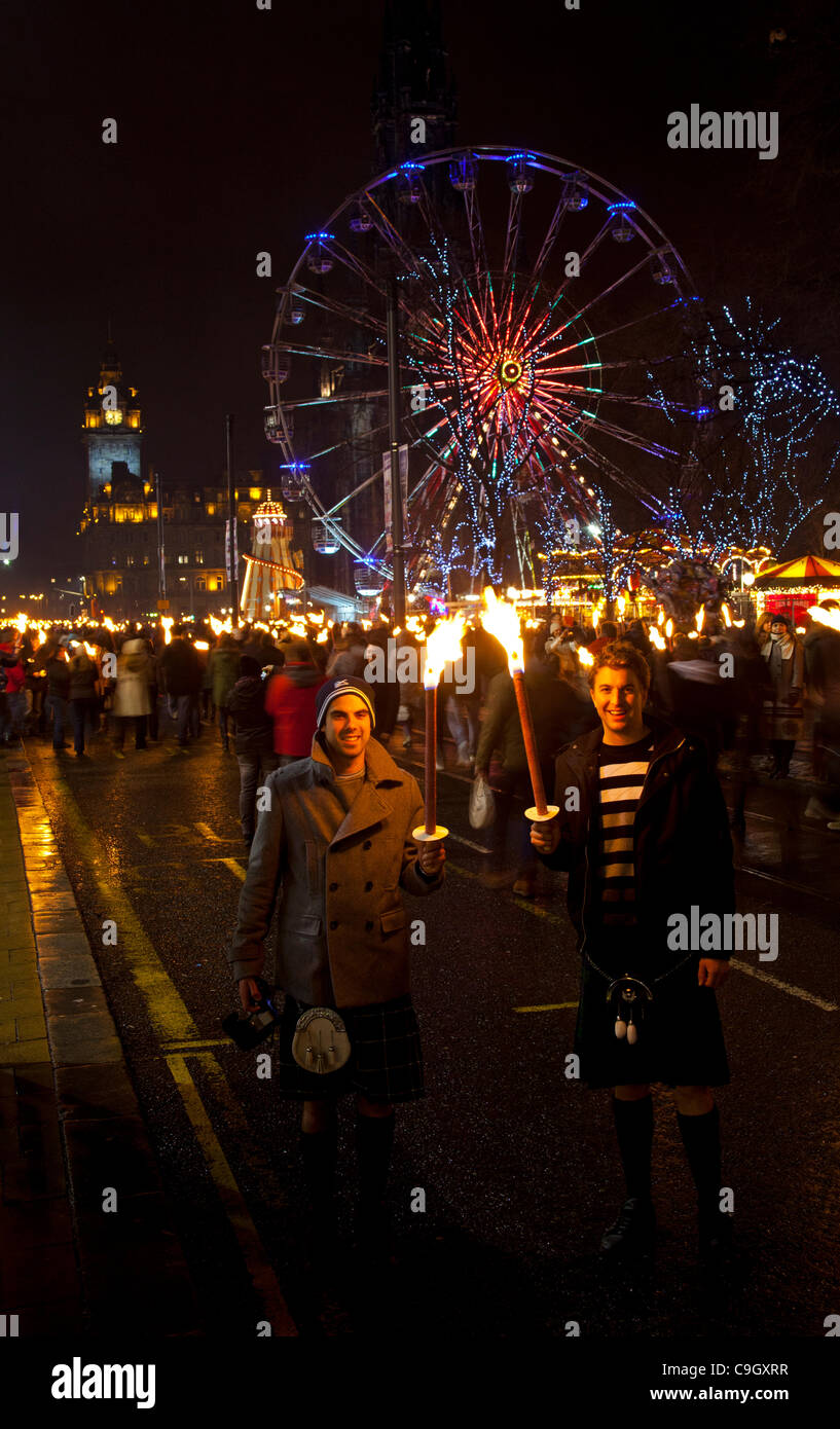 Procesión de antorchas (Afore) la noche del 30 de diciembre de 2011 Comienzo de las celebraciones de Año Nuevo en Princes Street, en el centro de la ciudad de Edimburgo, Escocia, Reino Unido, Murray y Callum Foto de stock