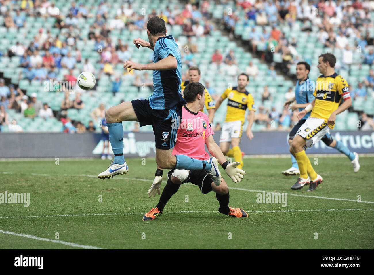 08.01.2012 Sydney, Australia.Sydney centrocampista Brett Emerton marquesina redondea el Keeper y cruza durante el partido de Liga entre Sydney Central Coast Mariners FC y jugado en el Estadio de Fútbol de Sydney. Foto de stock