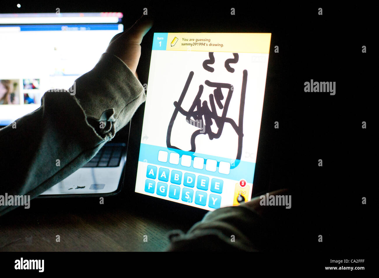 El 25 de marzo de 2012: una niña de 13 años utilizando la app dibujar algo sobre un nuevo Apple iPad 3 Tablet PC. Un pequeño OMGPOP, juegos basados en Nueva York empresa acaba de ser comprada por $180m (£113m) después de lanzar la app que fue descargado 35 millones de veces en las últimas seis semanas. Foto de stock