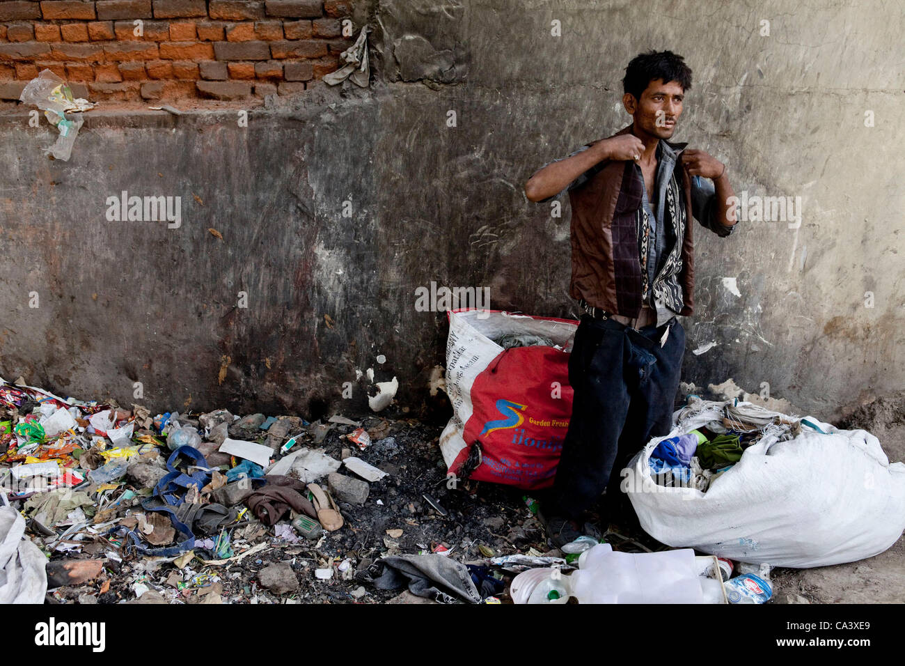 Un drogadicto trata sobre ropa nueva encontró mientras la recogida de  basura alrededor de Ghat nº 1 de la Yamuna Bazar. Los toxicómanos se  utilice la basura que recogen como su fuente