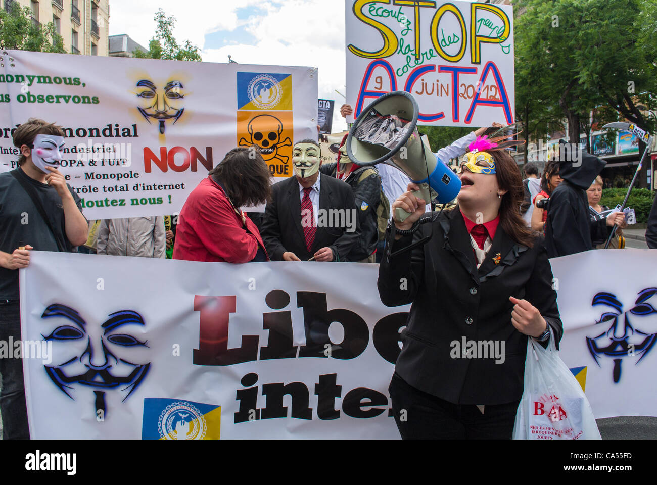 Activistas de un anti- ACTA Acuerdos de Internet, los que se oponen a la Ley de control de las comunicaciones y la censura de las redes de internet, sosteniendo pancartas y carteles de protesta, y máscaras, en una manifestación en París, Francia, Foto de stock