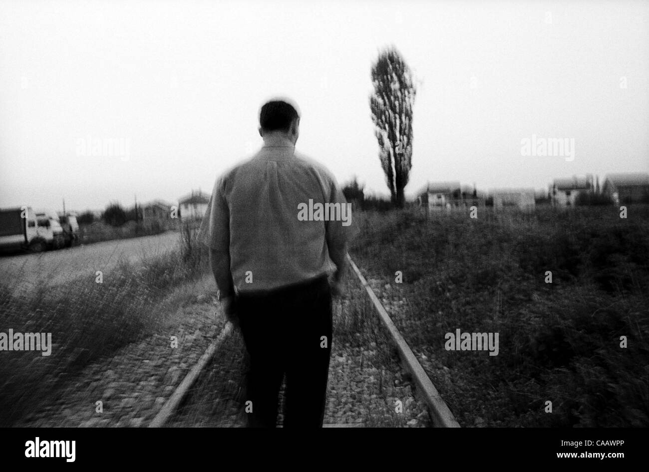 Eqrem Hoti paseos a lo largo de las vías del ferrocarril que corren a través de la aldea de Krushe e Mahde en Kosovo, donde más de cincuenta hombres fueron masacrados por paramilitares serbios en 1999. Foto de stock