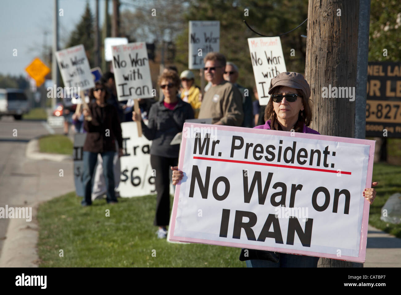 Bingham Farms, Michigan - los activistas de la paz mantenga signos opuestos a la guerra con Irán mientras espera para vehículos de escolta del Presidente Obama para pasar. El presidente estaba asistiendo a una campaña de recaudación de fondos en las cercanías. Foto de stock