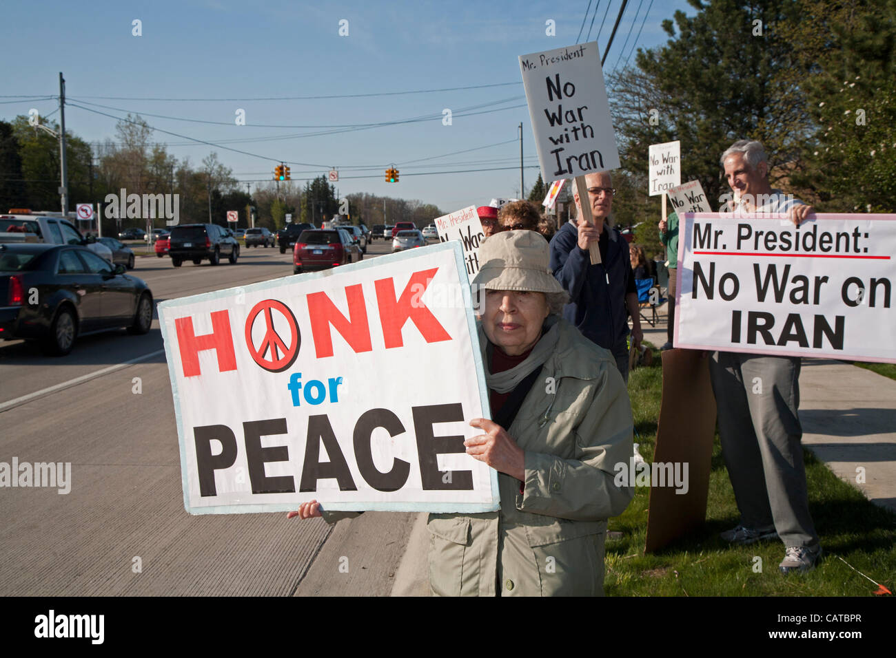 Bingham Farms, Michigan - los activistas de la paz mantenga signos opuestos a la guerra con Irán mientras espera para vehículos de escolta del Presidente Obama para pasar. El presidente estaba asistiendo a una campaña de recaudación de fondos en las cercanías. Foto de stock