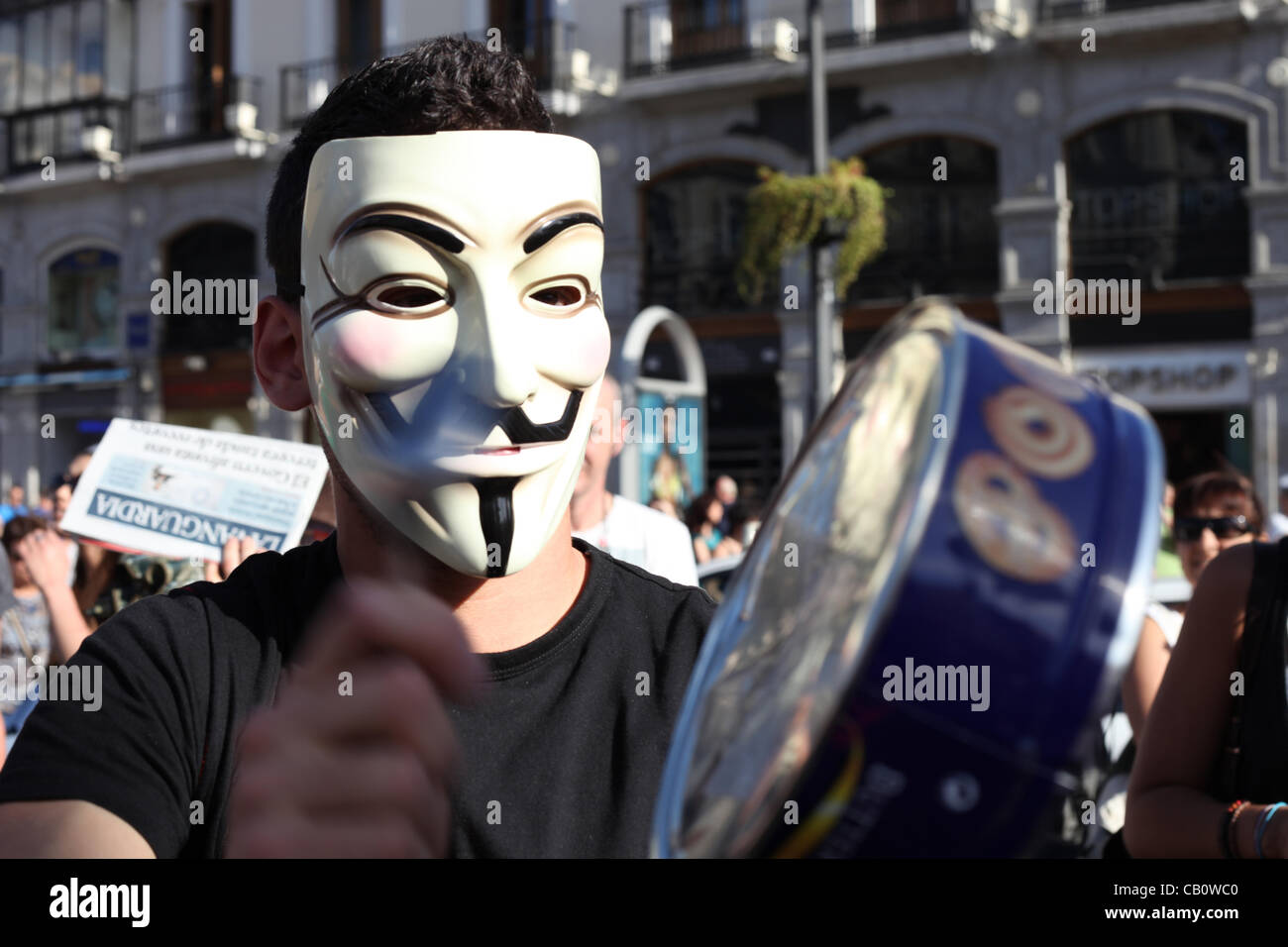 Madrid, España. Un hombre que llevaba una máscara de Guy Fox golpea sobre  un tambor de cambio durante una sesión de canto en la Puerta del Sol  durante una protesta que marcó